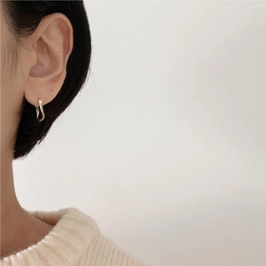 Minimalist 925 sterling silver curved hoop earrings worn by a model for a chic style