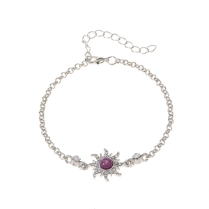 Detailed macro view of silver starburst bracelet featuring a purple center stone and crystals