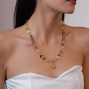 Détail du collier solaire bohème avec perles de verre ambrées sur le cou d'un mannequin