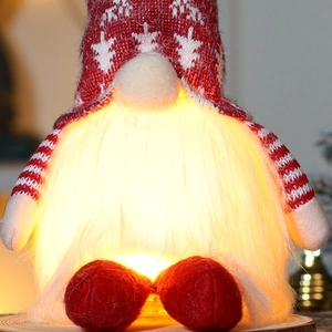 Close-up of a glowing Christmas gnome with red star hat and warm LED lights