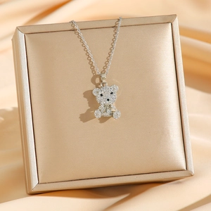 Collier avec pendentif ours étincelant et zircons pavés sur une boîte cadeau élégante