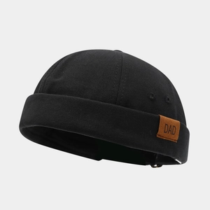 Détail du bonnet marin noir avec un écusson DAD en cuir marron vintage sur le côté