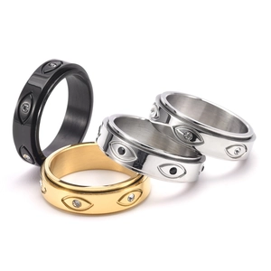 Dettaglio degli anelli rotanti con motivi occhio del male in oro, argento e nero lucido