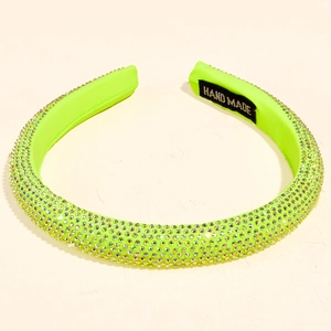 Detail shot of neon green rhinestone headband with handmade woven label on inside