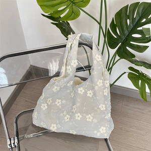 Detail of light blue mesh tote bag with delicate white 3D floral embroidery