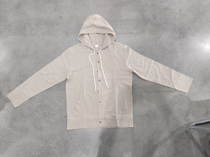 Macro shot of linen fabric texture on beige hooded shirt with buttons and drawstring