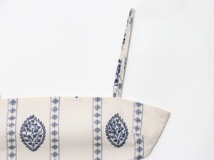 Detail of neckline with vintage blue leaf print on beige cotton-linen fabric dress