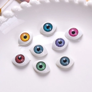 Set of 12x16mm acrylic oval doll eyes with colorful iris patterns in a ceramic dish