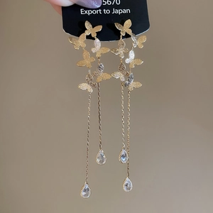 Detail of 18K gold plated butterfly tassel earrings with sparkling drop crystals