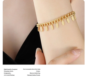 Detail of 18k gold plated surgical titanium steel bracelet with oval charms on wrist