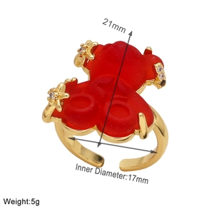 Detailed view of adjustable gold-plated ring with translucent red bear and zircon accents