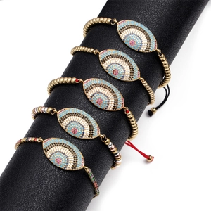 Detailed view of adjustable Evil Eye bracelets with colorful zircons on a display stand