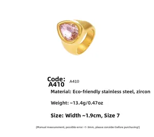 Détail d'une bague en acier titane doré avec zircon rose en goutte et données de taille