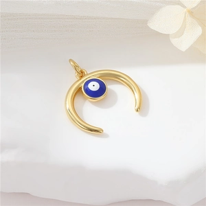 Detailed view of a gold crescent moon pendant with a blue evil eye bead for DIY jewelry
