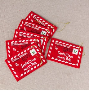Detail of red felt Christmas envelopes for cards with gold string and printed holiday text
