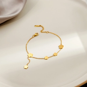 Detailed close-up of golden floral station bracelet with S925 hallmark on a minimalist tray