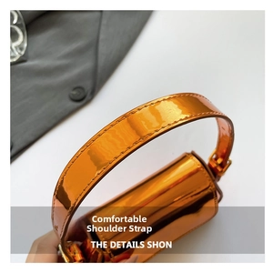 Detail of the comfortable wide shoulder strap on this metallic orange patent leather bag