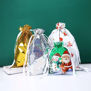 Detail of Christmas drawstring gift bags featuring festive patterns and gold ribbon ties