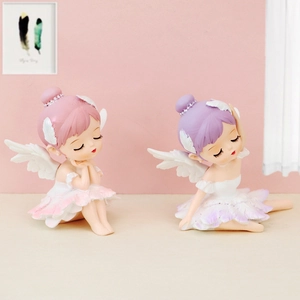 Detailed view of two resin ballet girl figurines in pink and purple outfits with wings