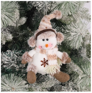 Detail showing a white plush snowman ornament with knitted hat and scarf on a snowy tree
