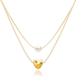Detail of double-layer gold necklace featuring a white pearl and a 3D heart pendant