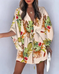 Detail of V-neck summer dress with green palm leaf print and drawstring waist ties