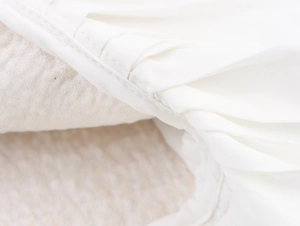 Détails des coutures raffinées et plis sur cette robe blanche en tweed à paillettes