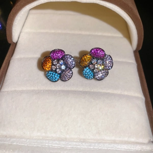 Macro detail of multi-color zircon flower earrings with sparkling stones and silver needle