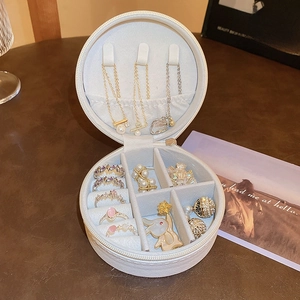 Detail view of round white jewelry box with necklace hooks and multi-layer inner slots