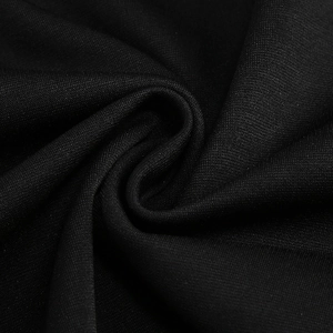 Macro shot of black knitted fabric texture with elegant spiral pleated draping detail