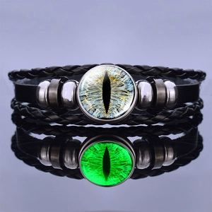 Luminous green dragon eye leather bracelet with multilayer braided bands on reflective surface