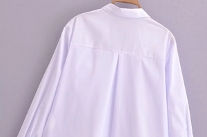 Rear view of a white V-neck blouse with a box pleat detail and a soft draping fabric