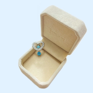 Detail of silver heart belly ring with blue star and oval stones in a velvet box