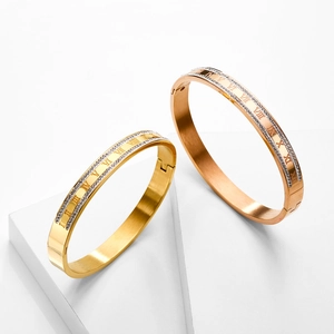 Detail of 18K gold-plated titanium bracelets with Roman numerals and pavé crystals
