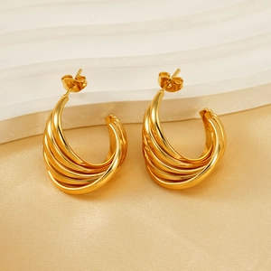 Polished golden multi-layered C-shape hoop earrings on elegant silk fabric background