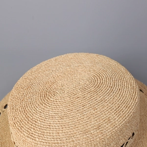 Detailed close-up of the spiral weave texture on a natural straw sun hat top