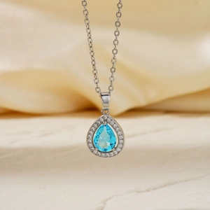 Elegant silver necklace featuring a teardrop-shaped blue zircon pendant with diamond accents