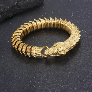 Dettaglio macro del bracciale testa di drago dorata con trama a scaglie e chiusura ad anello