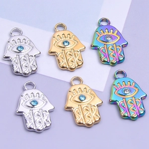 Détail de pendentifs main de Hamsa en or, argent et acier arc-en-ciel avec cristaux
