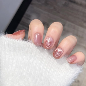 Pink cat eye press-on nails with 3D heart design on white cozy sweater background