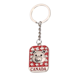 Metal Canada souvenir keychain featuring a silver bear head, maple leaf and red Canada text