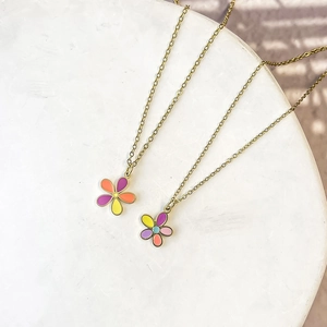 Macro detail of gold stainless steel necklace with colorful enamel flower pendants
