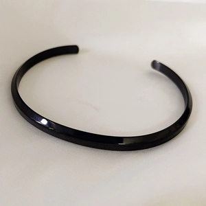 Minimalist black C-shaped stainless steel open bangle bracelet with a polished finish