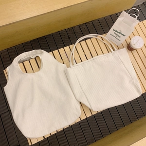 Minimalist cream canvas tote bag with herringbone texture shown in an urban lifestyle setting
