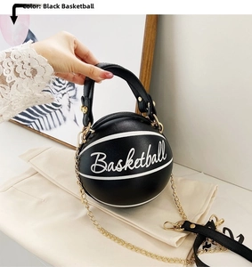 Detail of black basketball-shaped handbag with white text and gold chain strap