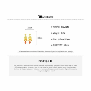 Detail view of yellow-orange raffia tassel earrings with 8.5cm by 2.5cm size and iron posts