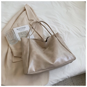 Dettaglio della borsa tote beige in ecopelle con trama materica e chiusura in metallo