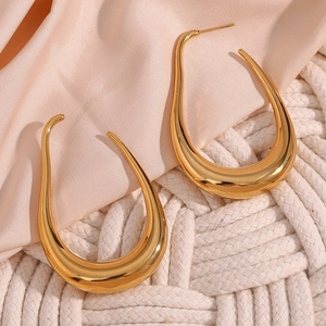 Polished 18K gold plated stainless steel U-shaped hoop earrings on soft pink silk background