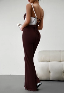 Detail of deep brown ribbed backless jumpsuit showing halter neck and slim fit silhouette