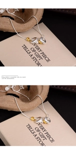 Detailed view of bicolor gold and silver ring pendants on a delicate snake chain
